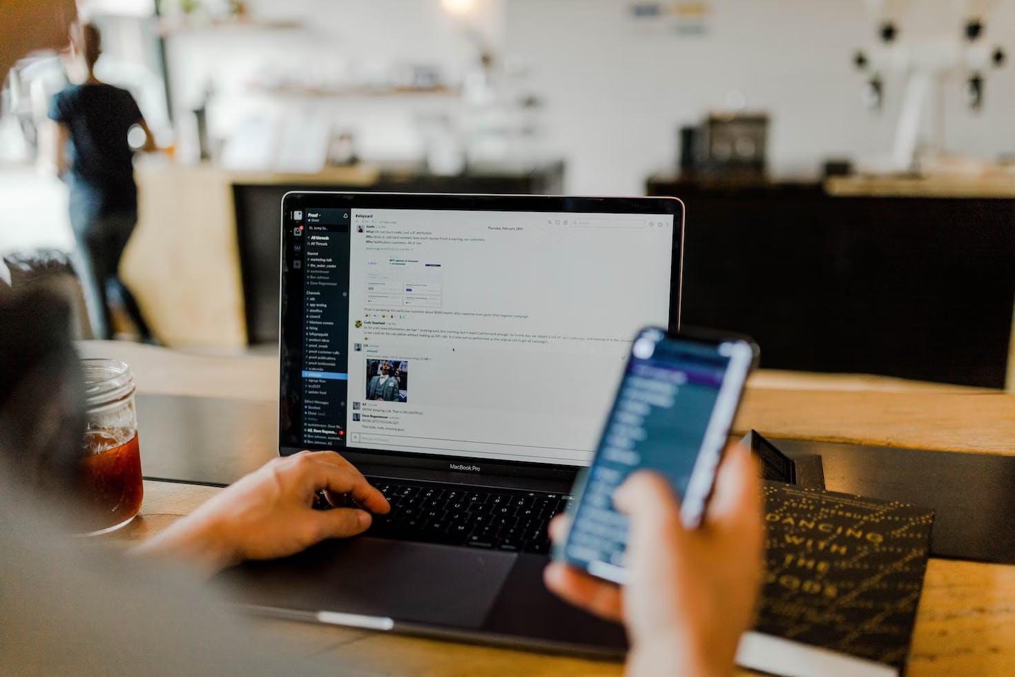 A person using a laptop and phone at the same time